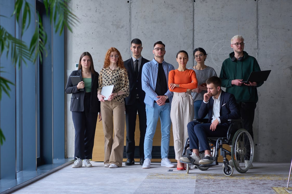 Diverse group of business people, including a businessman in a wheelchair in a modern office